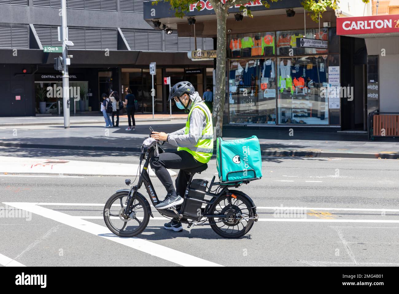 Essenslieferung Radfahrer fährt mit dem E-Bike und trägt einen Fahrradhelm Sydney, NSW, Australien Stockfoto