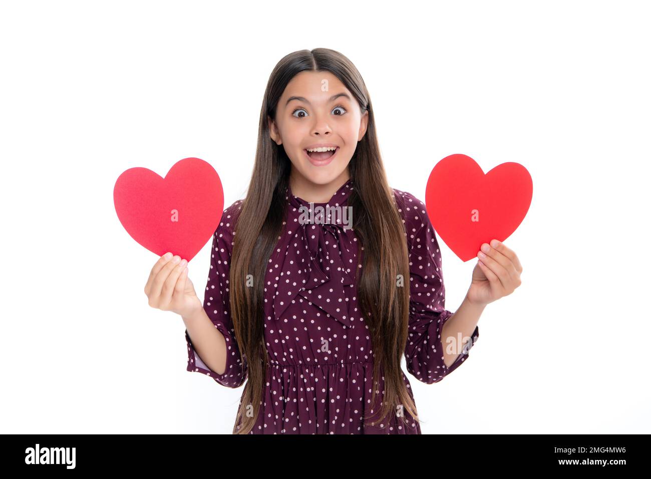 Liebenswertes, romantisches Teenager-Mädchen mit rotem Herz Symbol der Liebe für den Valentinstag isoliert auf weißem Hintergrund. Portrait eines emotional überraschten, aufgeregten Teenagers Stockfoto