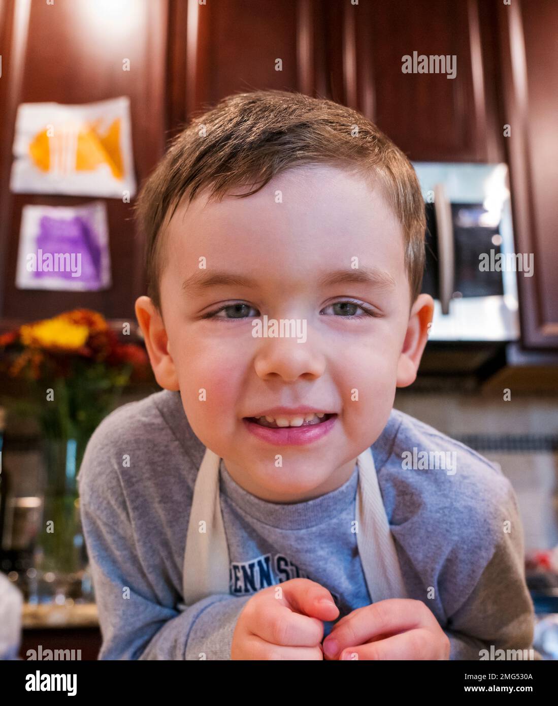 Foto eines 3-jährigen Jungen, der in der Küche hilft Stockfoto