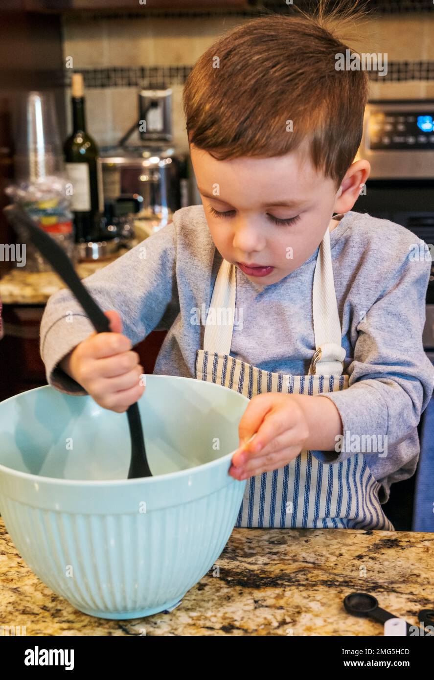 Drei Jahre alter Junge, der Großmutter beim Backen eines Apfelkuchen an Thanksgiving hilft; Philadelphia; Pennsylvania; USA Stockfoto
