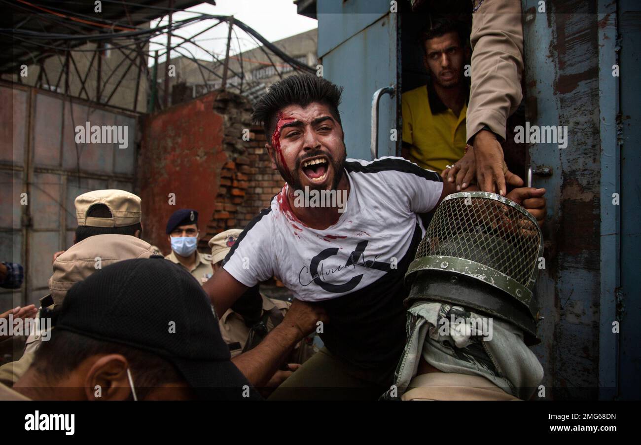 Indian policemen detain a Kashmiri Shiite Muslim as he attempts, along ...