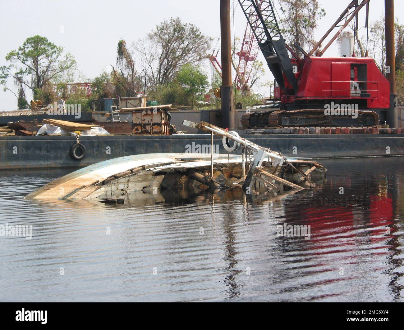 Nachwirkungen – verdrängte Boote – Hafensicherheitseinheit (PSU) 309 – 26-HK-27-79. Überwiegend unter Wasser stehende Schiffe in der Nähe von Industrieanlagen--Chris Tramp Foto. Hurrikan Katrina Stockfoto
