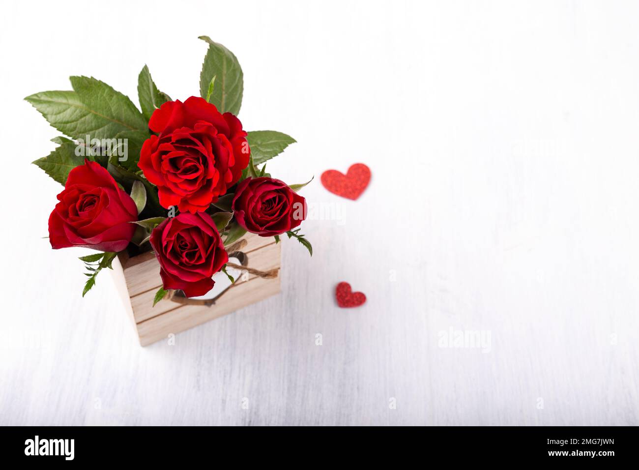 Strauß roter Rosen im Holzkasten auf weißem Hintergrund Stockfoto