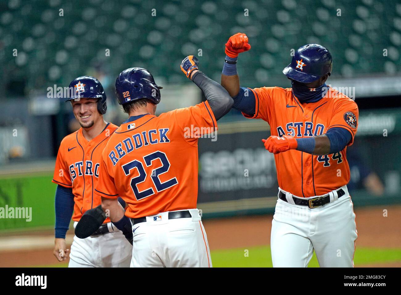 Houston Astros' Yordan Alvarez (44) celebrates with Josh Reddick (22) and Alex Bregman after they scored on Alvarez's three-run home run against the Seattle Mariners during the first inning of a baseball game Friday, Aug. 14, 2020, in Houston. (AP Photo/David J. Phillip) Stockfoto