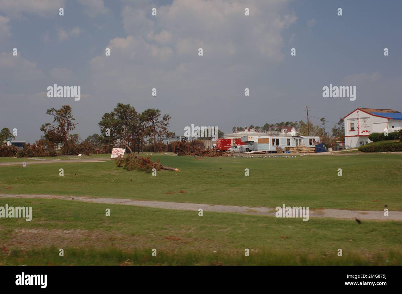 Navigationshilfen - 26-HK-63-58. Entwurzelter Baum in der Nähe des Feldes, Wohnwagens und Gebäudes. Hurrikan Katrina Stockfoto