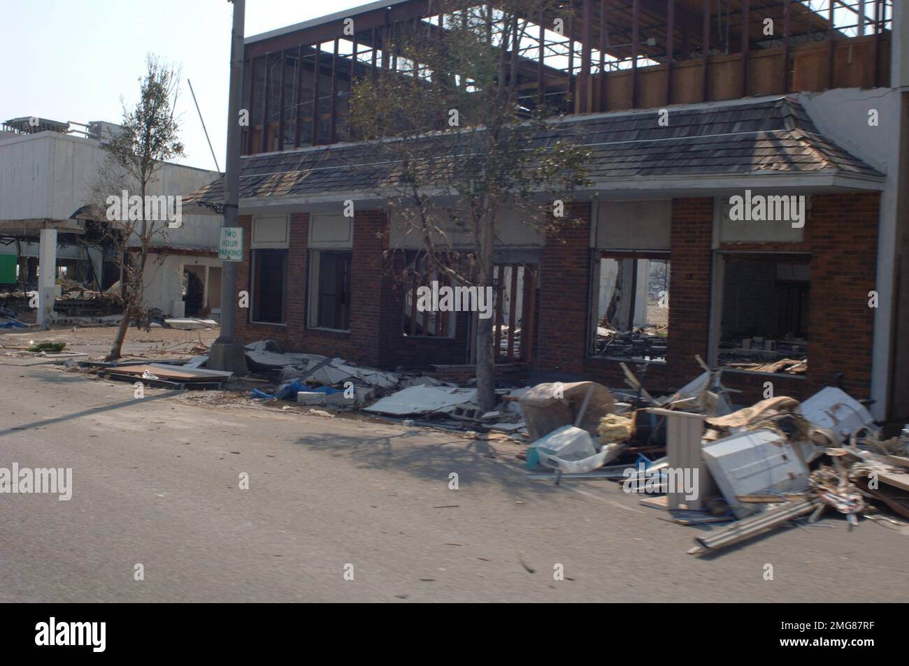 Navigationshilfen - 26-HK-63-44. Stark beschädigtes Gebäude und Schutt entlang der Straße. Hurrikan Katrina Stockfoto