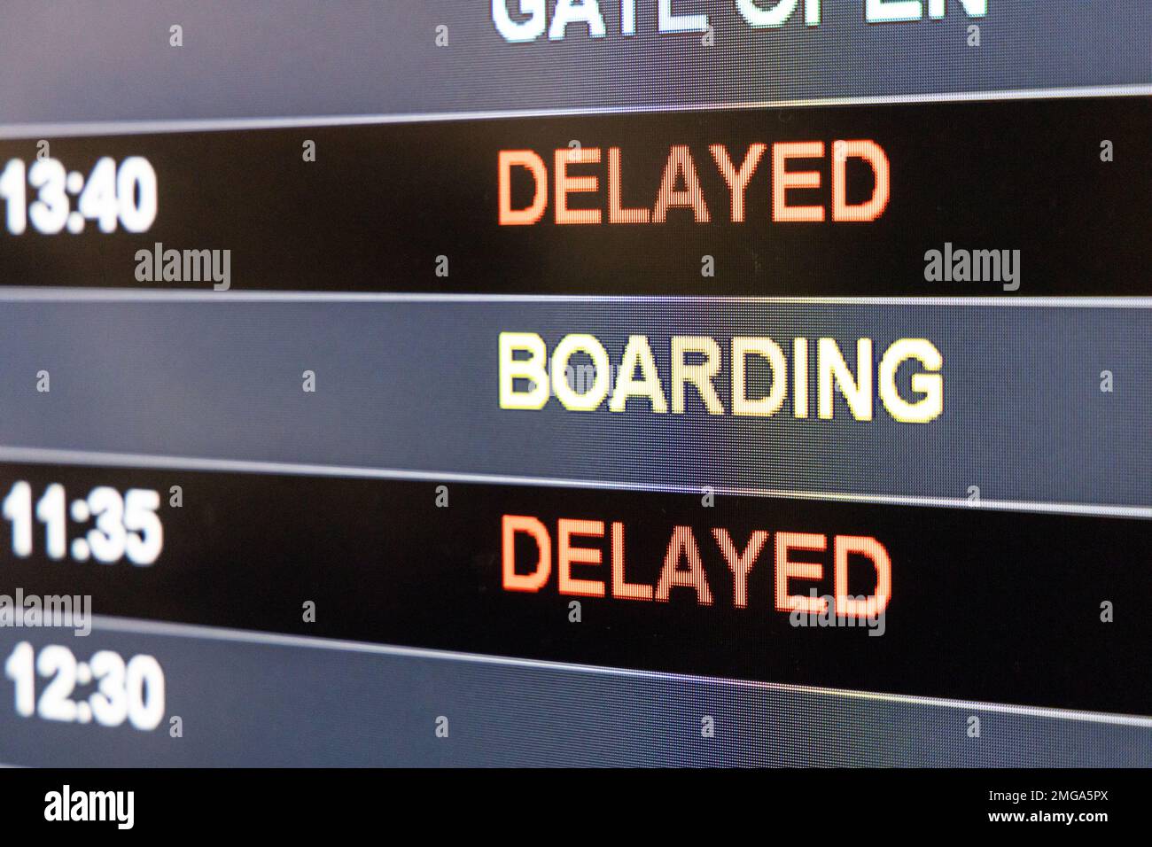 Nahaufnahme der digitalen Anzeigetafel für Fluginformationen am Flughafen mit Fokus auf dem Wort Verspätung Stockfoto