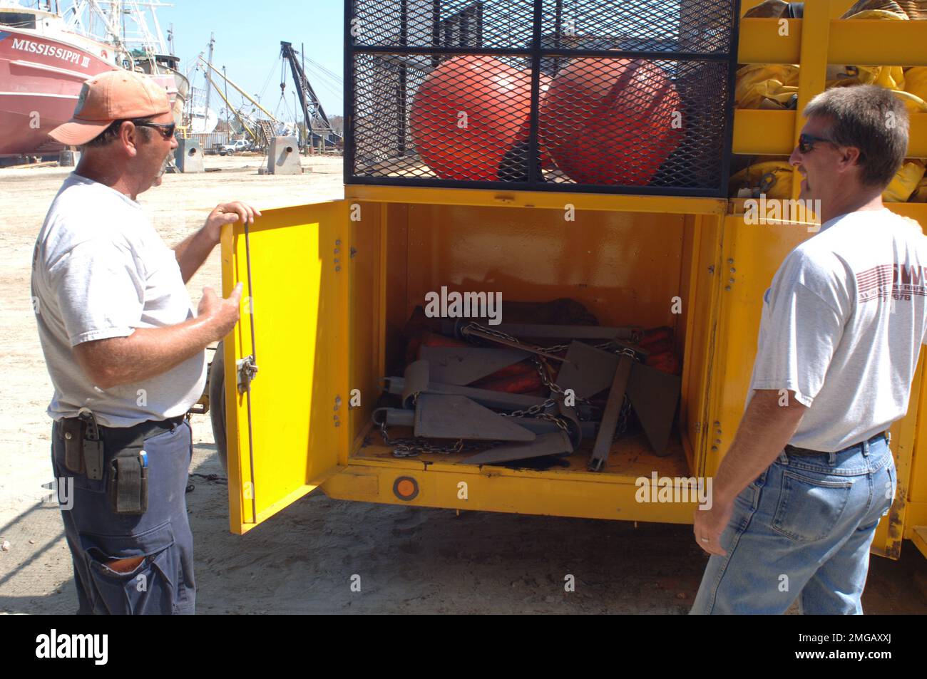 Personal der Küstenwache und zivile Operationen - 26-HK-72-57. Zwei Zivilisten in der Nähe eines Fahrzeugs mit Navigationshilfen. Hurrikan Katrina Stockfoto