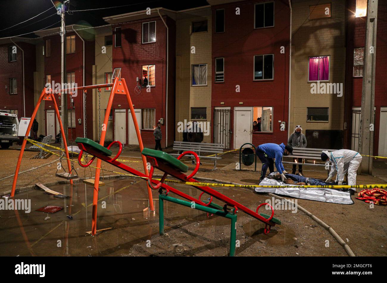 A relative and forensic worker remove the body of of Cesar Gallardo from a children's playground in the Villa Nueva Esperanza neighborhood of San Bernardo, on the outskirts of Santiago, Chile, Wednesday, July 1, 2020. Gallardo was a homeless man welcomed a month ago by residents who organized outdoor soup kitchens for hundreds daily, where he ate. His death, by unknown causes, has worried neighbors that he might have contracted and died of COVID-19. (AP Photo/Esteban Felix) Stockfoto
