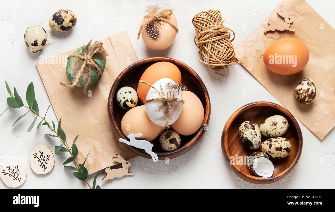 Ostereier mit natürlichen Materialien auf weißem Hintergrund. Draufsicht. Minimalistische Einrichtung zu Ostern. Stockfoto