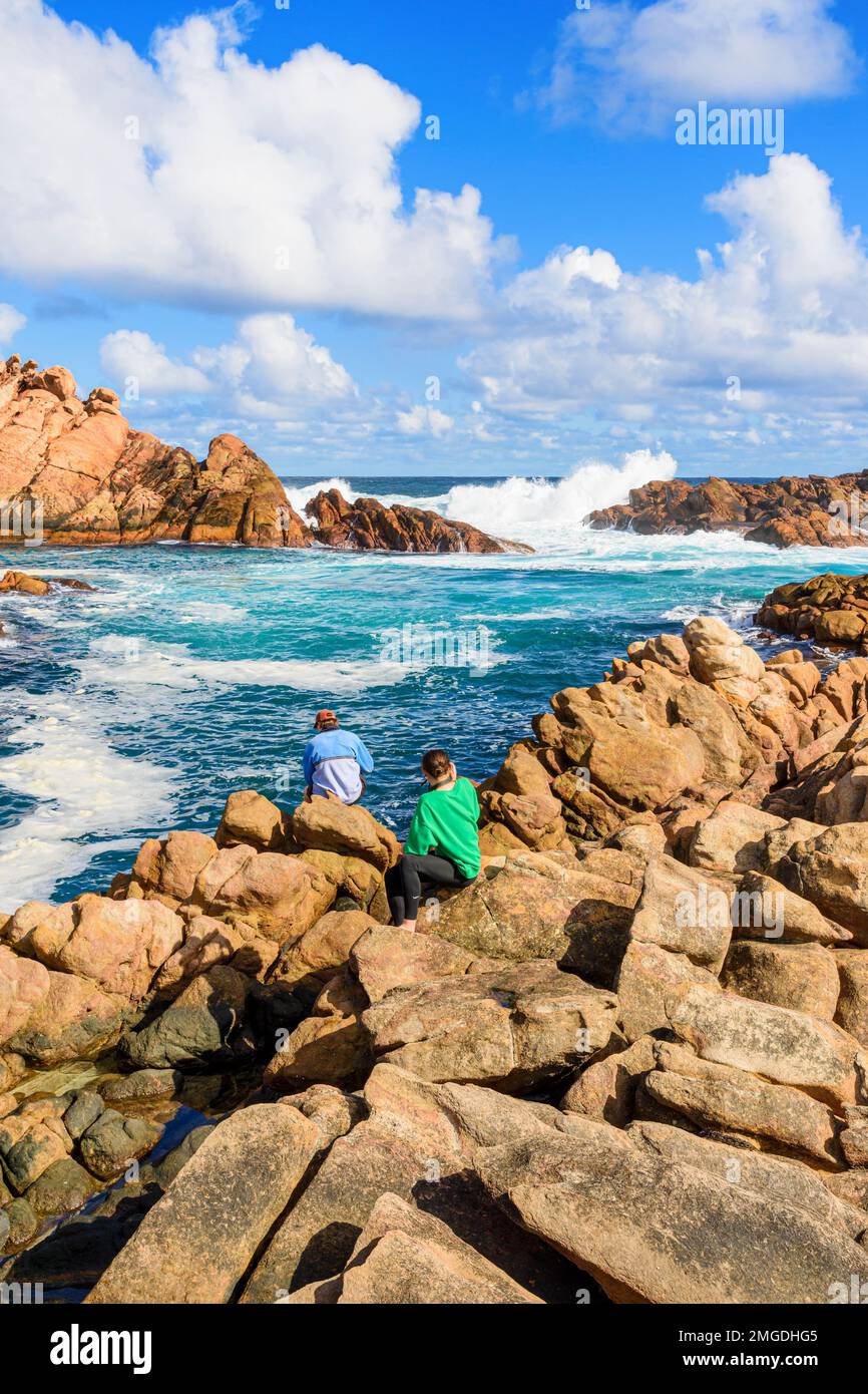 Menschen, die die Gezeiten des Wassers durch den engen Granitkanal von Canal Rocks, Leeuwin-Naturaliste National Park, Westaustralien beobachten Stockfoto