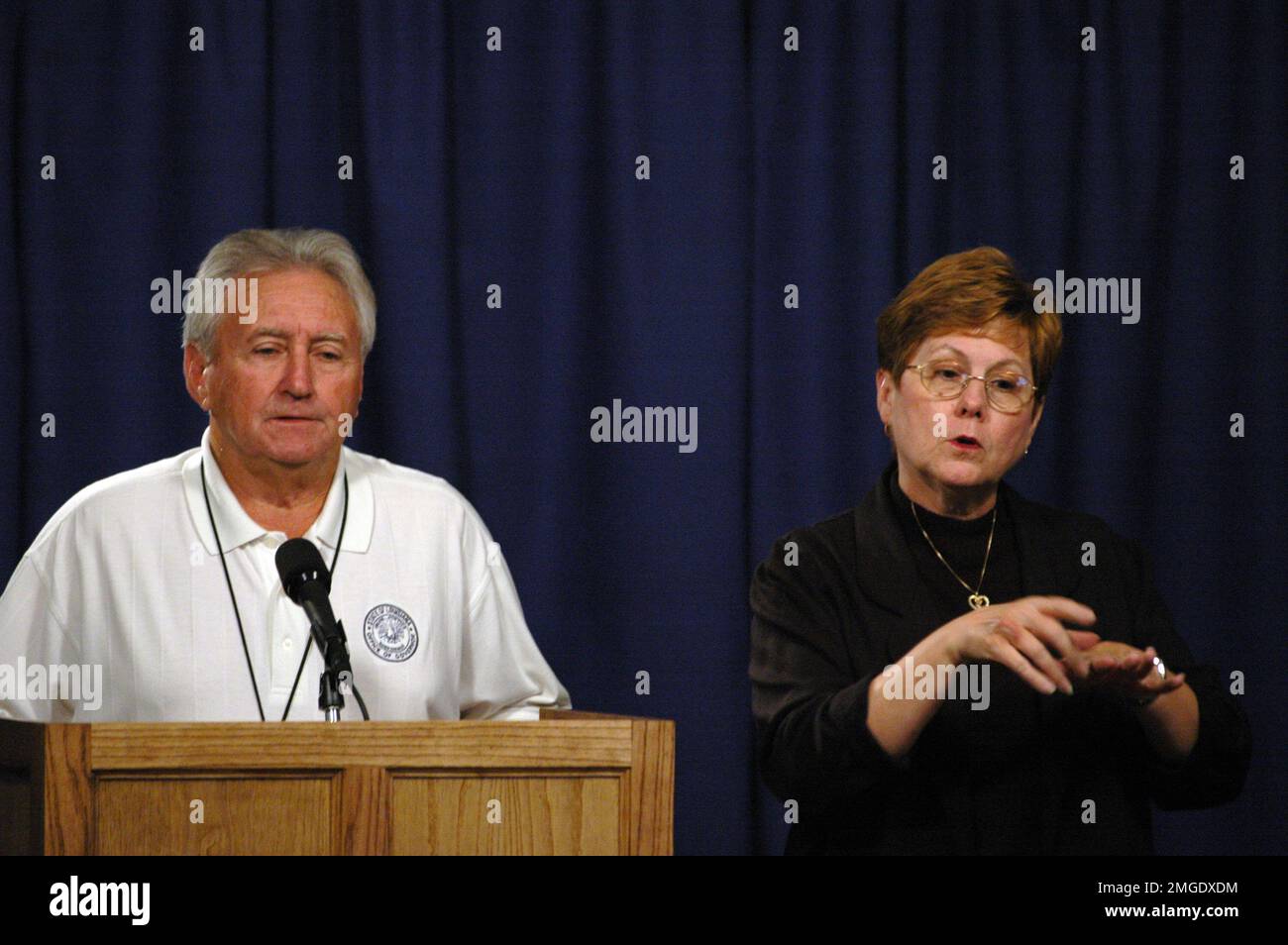 Küstenwache - Pressekonferenz - 26-HK-83-32. 930 Pressekonferenz--STAATSBEAMTER AUF dem Podium. Hurrikan Katrina Stockfoto