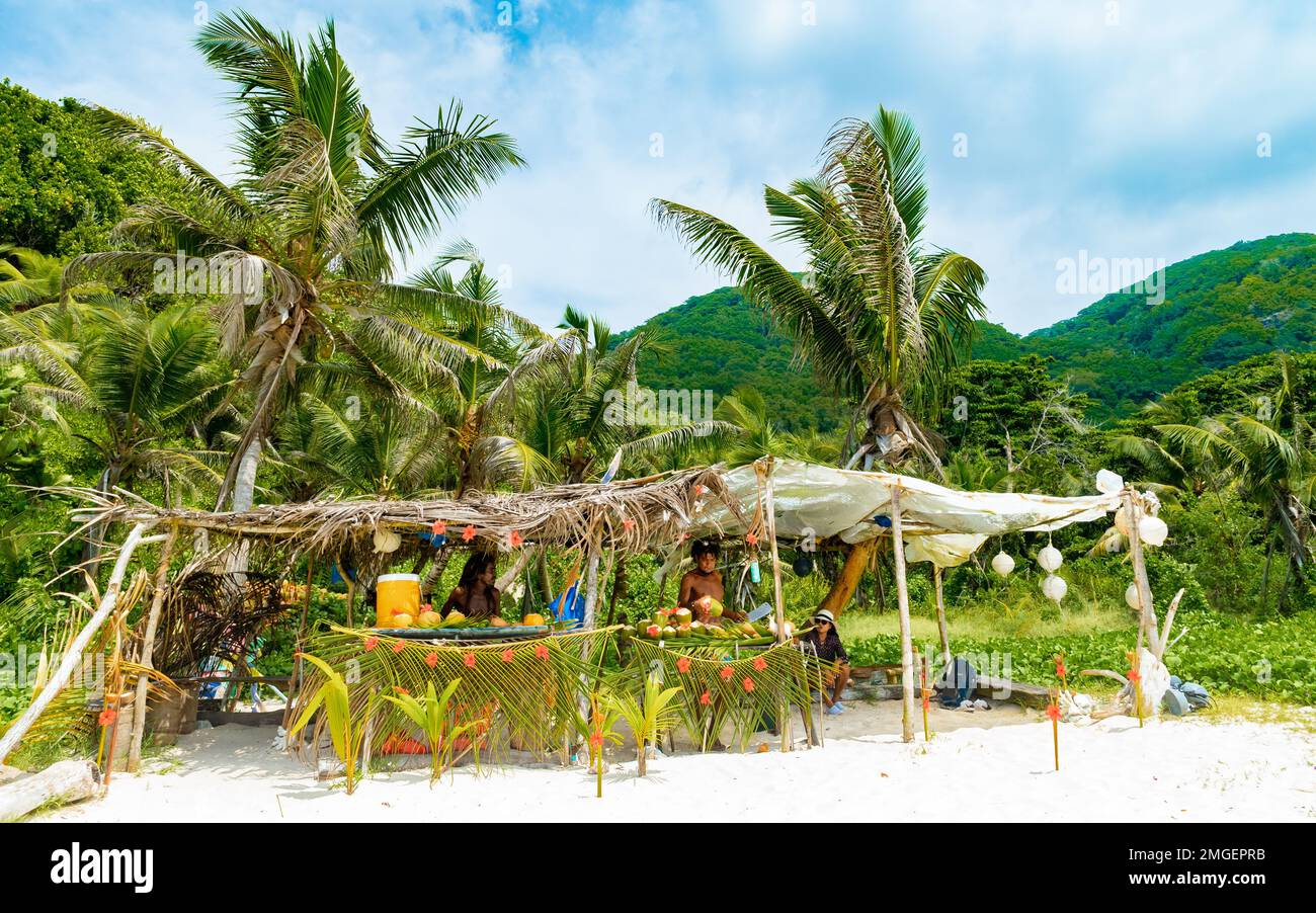 La Digue Seychellen 2018. März, Leute, die Kokosnussgetränke am Strand von Grand Anse verkaufen Stockfoto