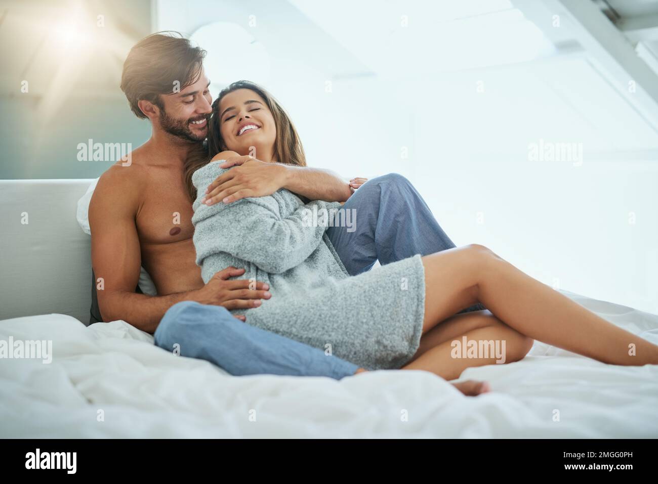 Teilen wir uns etwas Körperwärme. Ein liebevolles junges Paar, das einen intimen Moment im Bett teilt. Stockfoto
