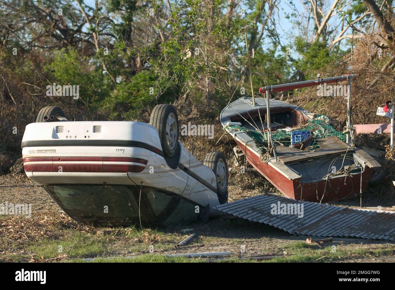 Nachtruhe - Pfarrei - 26-HK-42-60. Plaquemineschäden--umgestürztes Fahrzeug und verlorenes Boot in der Nähe von Bäumen--von Andrea Booher-FEMA. Hurrikan Katrina Stockfoto