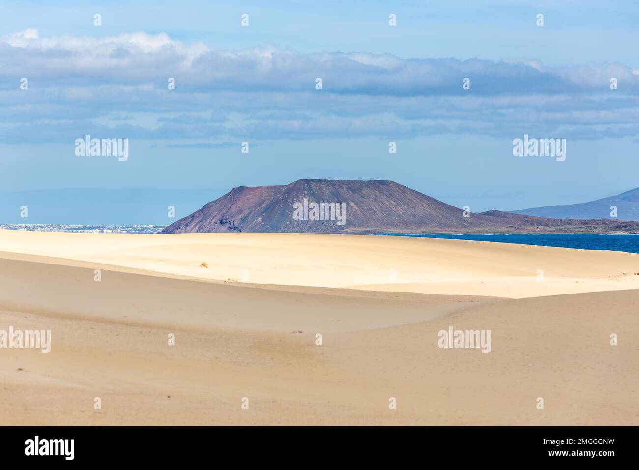 Dunkle Berghänge am Horizont des Dünenfeldes von Corralejo. Fuerteventura, Kanarische Inseln. Stockfoto