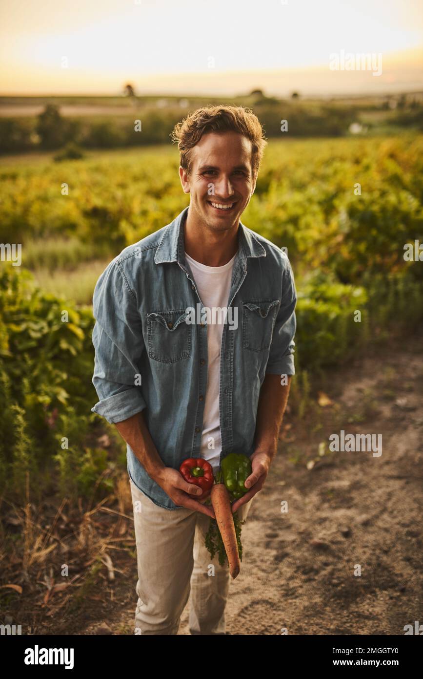 Sieh weg. Ein junger Bauer, der herumalbert und mit seinem Gemüse albern ist. Stockfoto