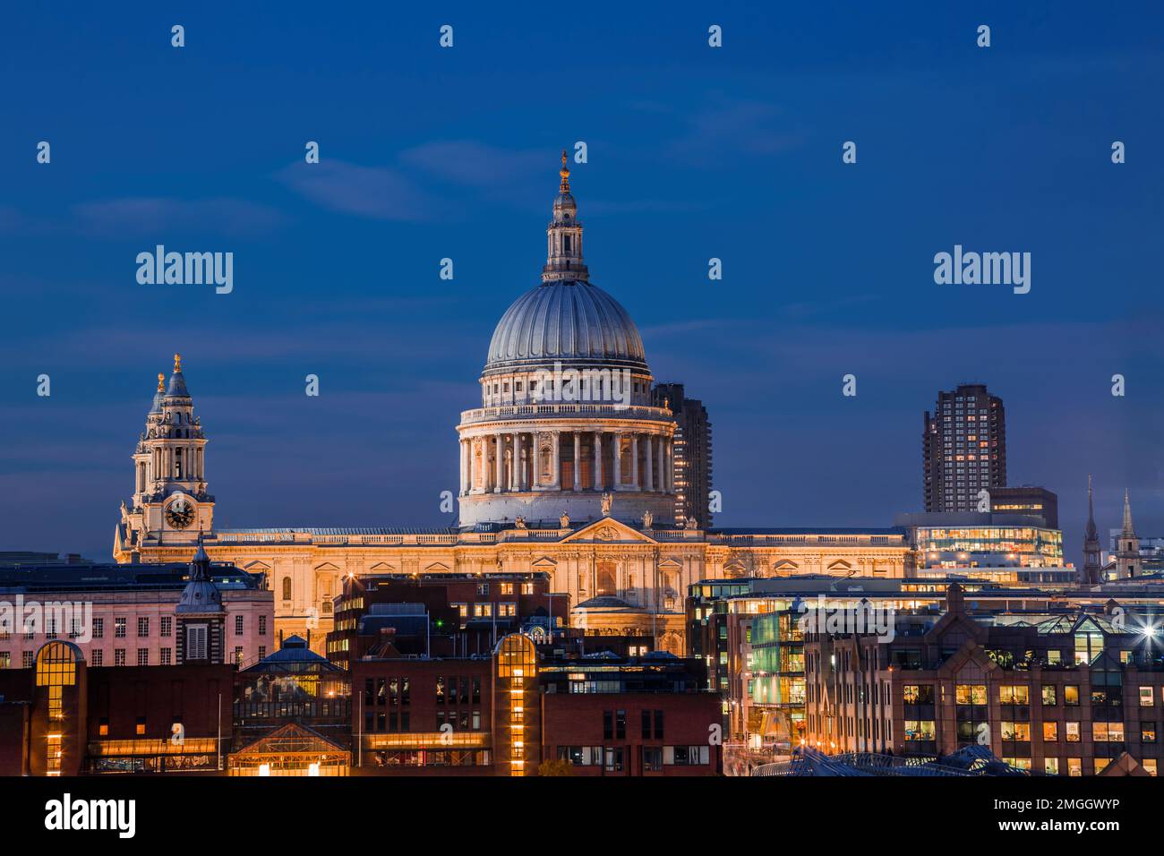 London, Großbritannien - Beleuchtete St. Paul's Cathedral zur Blue Hour mit Wolkenkratzern im Hintergrund und klarem blauen Himmel Stockfoto
