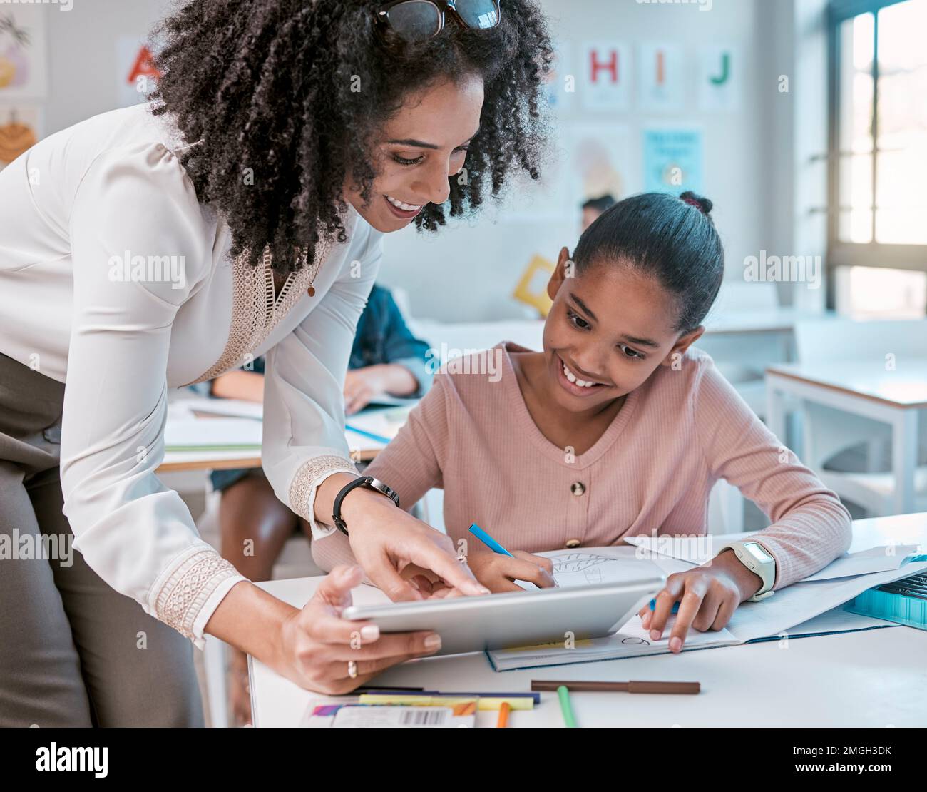 Tablet-Schulung, Lehrerin und Kind lernen, Schreiben und digitale Unterstützung, Helfer und Mentor im Klassenzimmer. Schwarze Frau oder Person, die das Kind unterrichtet Stockfoto