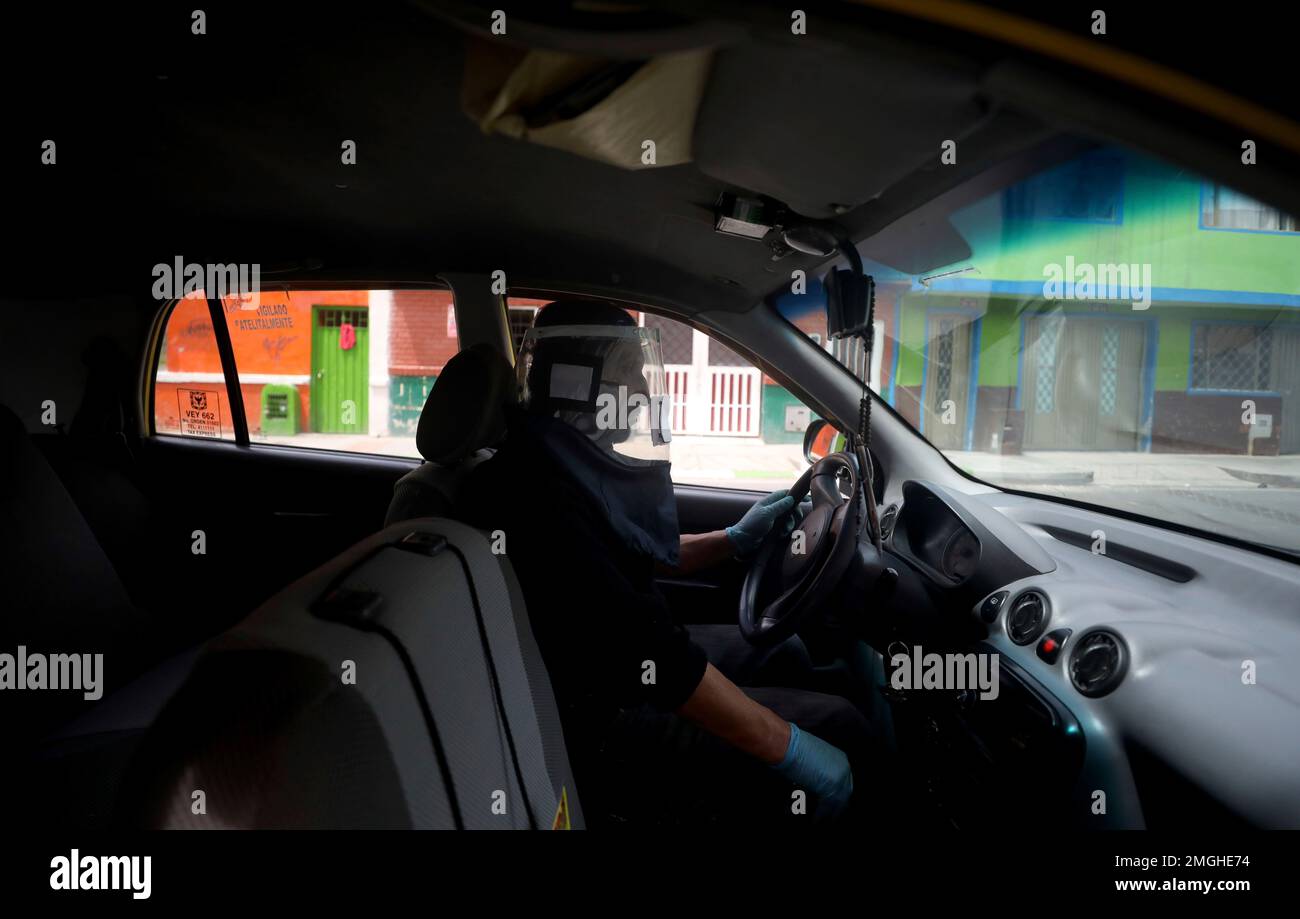 A taxi driver wears a mask called "mask of life" to protect himself against the spread of the new coronavirus during a lockdown to help contain the spread of COVID-19 disease, in Bogota, Colombia, Wednesday, April 29, 2020. Oscar Henao, also a taxi driver by profession and with his partner Adan Fajardo, owner of a small packaging workshop, created the plastic protection mask that they called the "mask of life, " to protect people from the ongoing pandemic. (AP Photo/Fernando Vergara) Stockfoto
