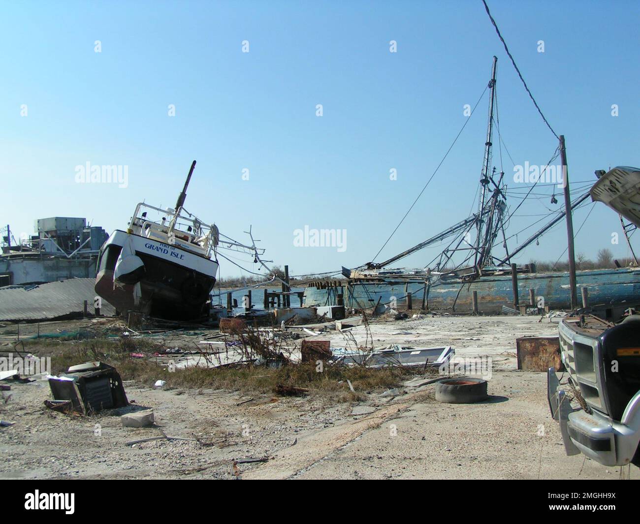 Aftermath - Jefferson Parish - 26-HK-38-55. Hafen von Grand-Isle-Schiff auf einem mit Trümmern gefüllten Dock verlegt, andere beschädigte Schiffe sichtbar. Hurrikan Katrina Stockfoto