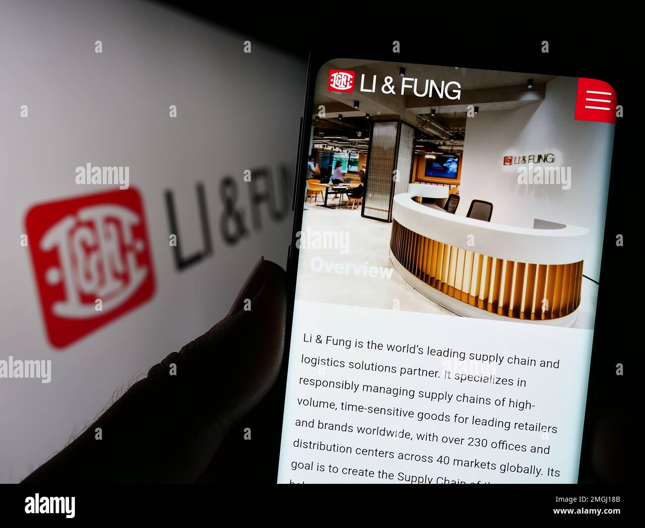 Person, die ein Smartphone mit der Website des Supply Chain Management Unternehmens Li Fung Limited auf dem Bildschirm mit Logo hält. Konzentrieren Sie sich auf die Mitte des Telefondisplays. Stockfoto