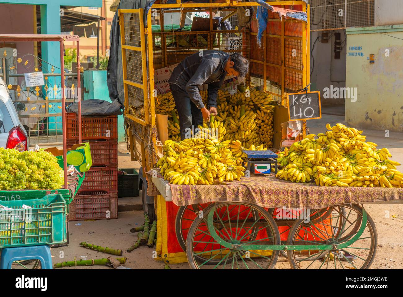 Puttaparthi, Andra Pradesh - Indien - 21,2023. Januar: Ein Mann, der Bananen von einem Tuk Tuk auf einem lokalen indischen Markt verkauft Stockfoto