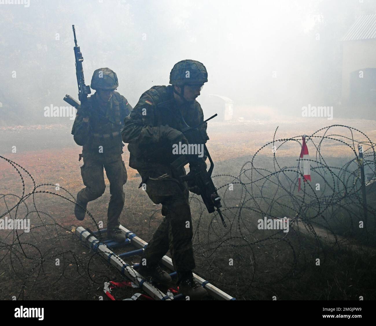 Deutsche Fallschirmjäger (Bundeswehr) mit der 4. Kompanie/Fallschirmjaeger, Regiment 26, überwindet ein Hindernis mit Stacheldraht während einer Übung zur städtischen Geländekriegsführung in Smith Barrack in Baumholder, Deutschland, 24. August 2022. Die Einheit trainierte in der Vorbereitung auf zukünftige Übungen und Szenarien für die Bewegung über das städtische Terrain Village. Stockfoto