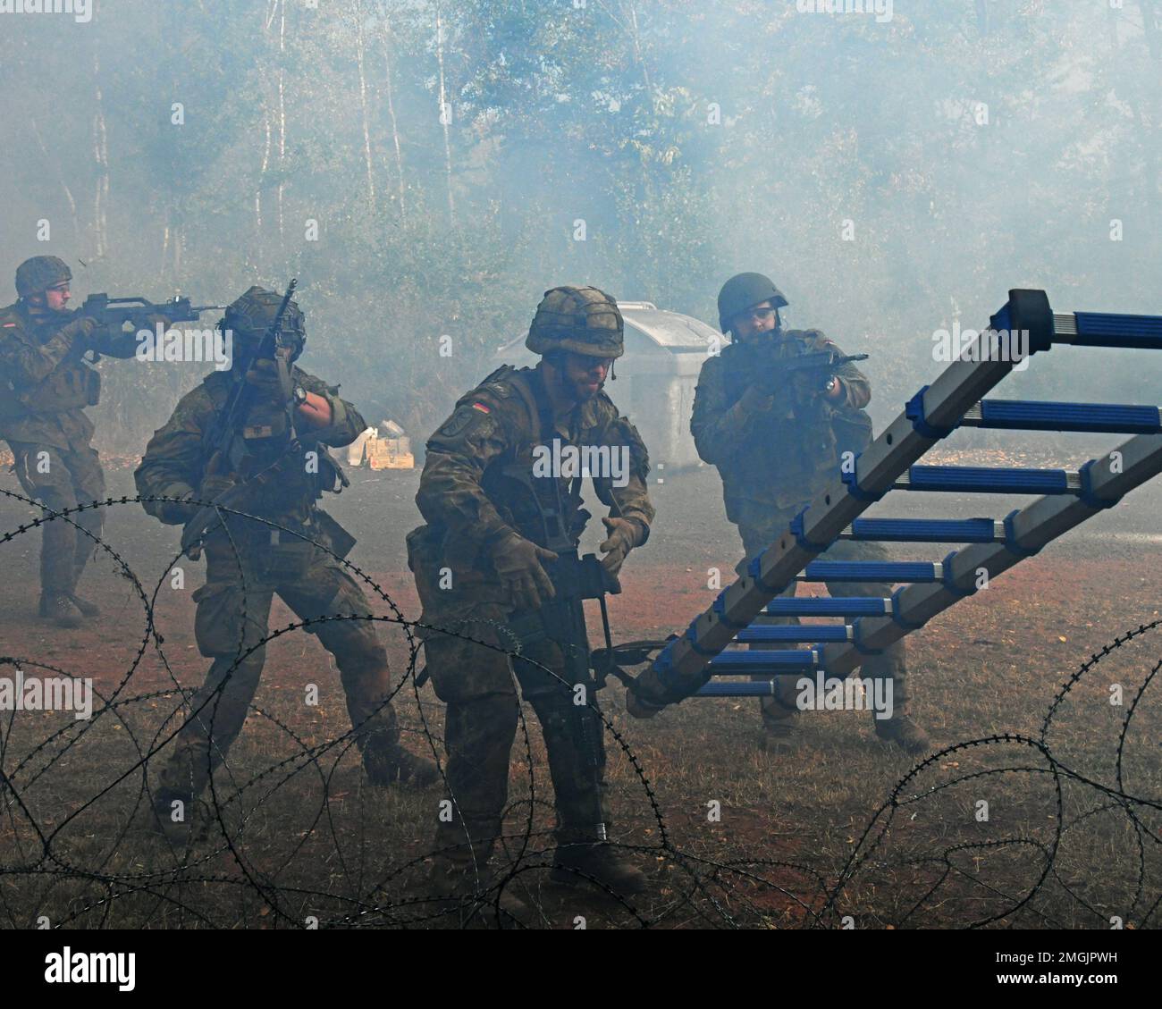 Deutsche Fallschirmjäger (Bundeswehr) mit der 4. Kompanie/Fallschirmjaeger, Regiment 26, überwindet ein Hindernis mit Stacheldraht während einer Übung zur städtischen Geländekriegsführung in Smith Barrack in Baumholder, Deutschland, 24. August 2022. Die Einheit trainierte in der Vorbereitung auf zukünftige Übungen und Szenarien für die Bewegung über das städtische Terrain Village. Stockfoto