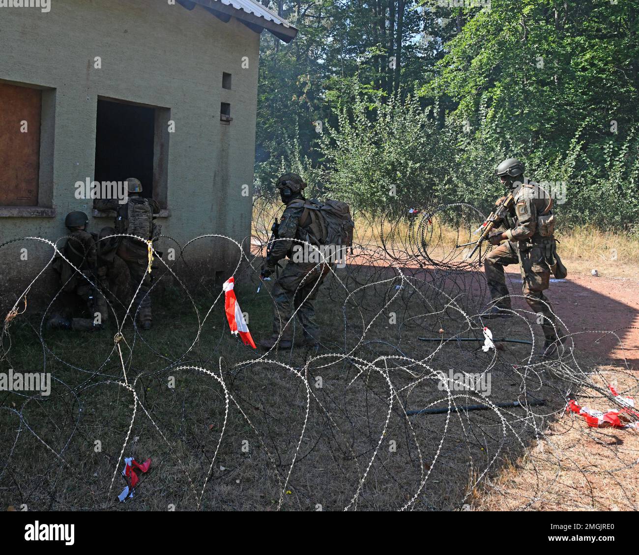 Deutsche Fallschirmjäger (Bundeswehr) mit der 4. Kompanie/Fallschirmjaeger, Regiment 26, Angriff auf ein vom Feind besetztes Gebäude während einer städtischen Geländekampfübung in Smith Barrack in Baumholder, Deutschland, 24. August 2022. Die Einheit trainierte in der Vorbereitung auf zukünftige Übungen und Szenarien für die Bewegung über das städtische Terrain Village. Stockfoto