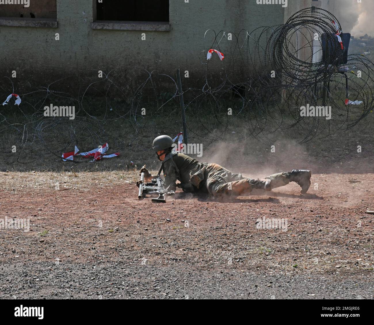 Ein deutscher Fallschirmjäger (Bundeswehr) mit der 4. Kompanie/Fallschirmjaeger, Regiment 26, geht in Position, um ein Stacheldraht-Hindernis während einer städtischen Geländekampfübung in Smith Barrack in Baumholder, Deutschland, am 24. August 2022 zu detonieren. Die Einheit trainierte in der Vorbereitung auf zukünftige Übungen und Szenarien für die Bewegung über das städtische Terrain Village. Stockfoto