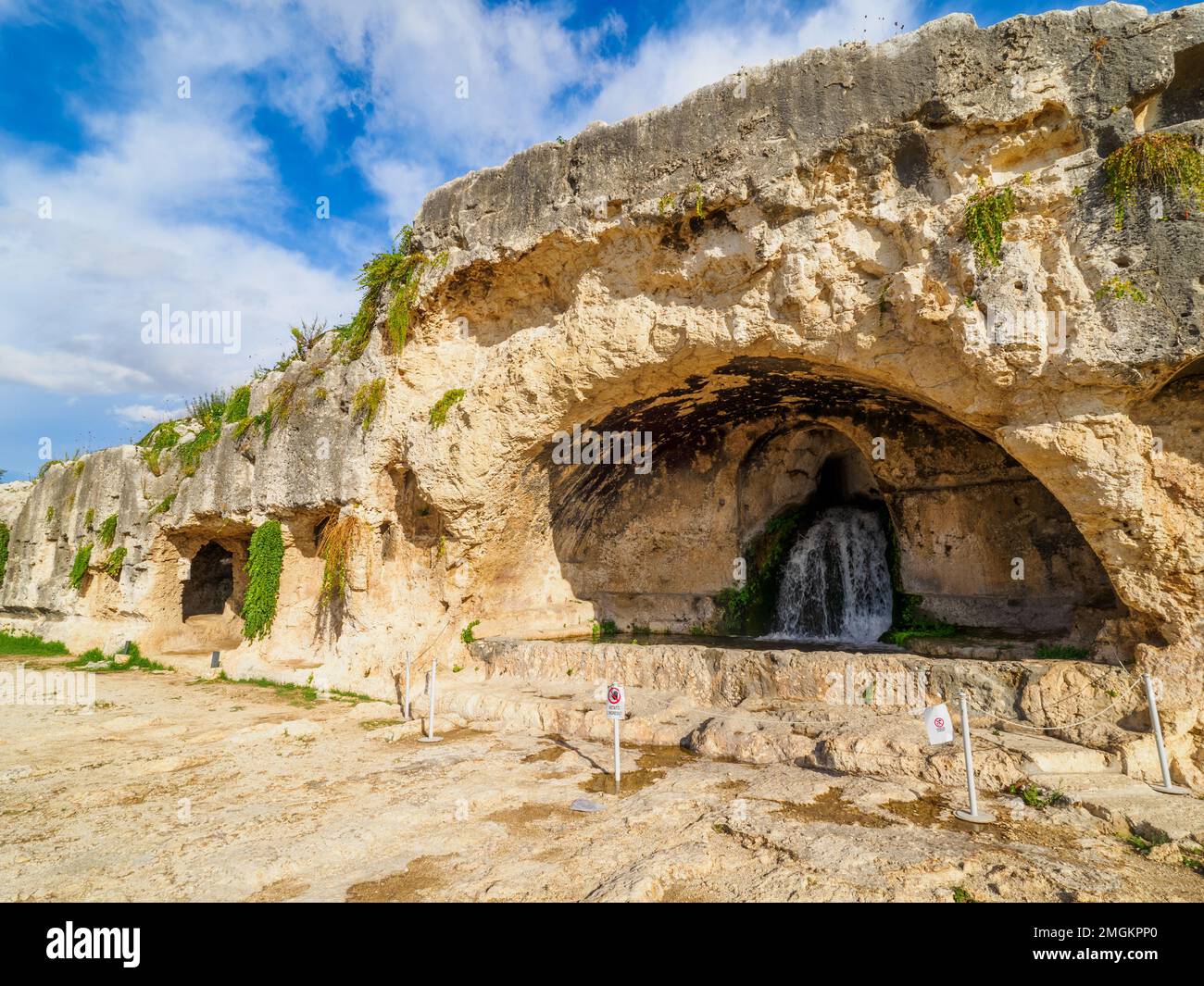 Die Grotta del Ninfeo ist eine künstliche Höhle im Felsen des Temenitenhügels (benannt nach den griechischen Temenos, „bewachsenes Viertel“) - Neapolis Archäologischer Park - Syrakus, Sizilien, Italien Stockfoto