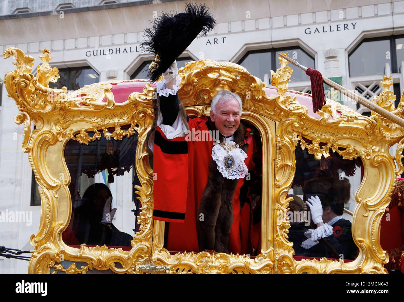 Lord Mayor, Nicholas Lyons, Leiter der City of London, winkt vom Gold State Coach in der Guildhall, als er der 694. Bürgermeister von London wird. Stockfoto