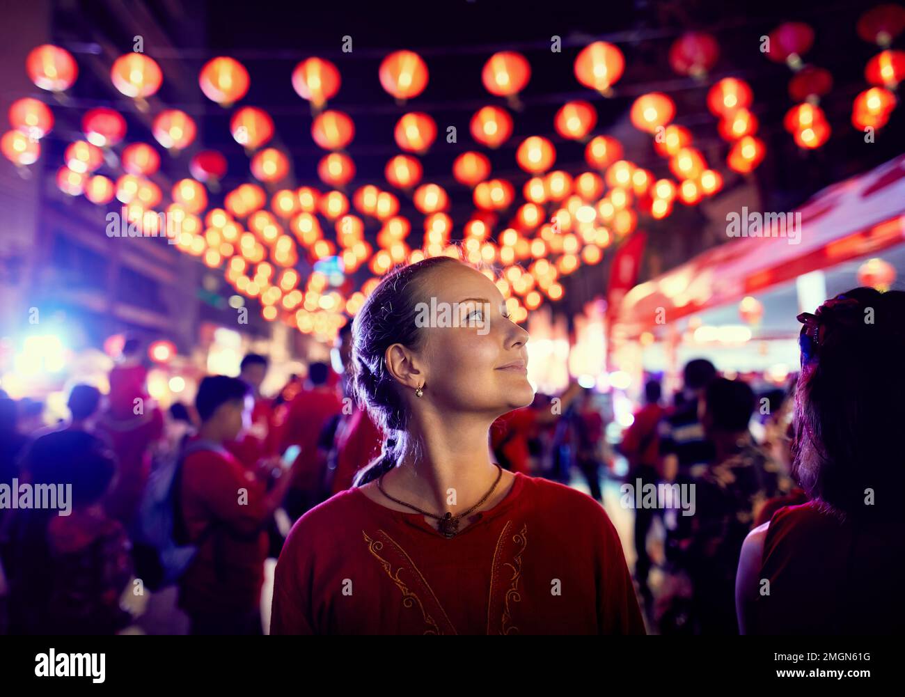 Touristin in rotem Hemd Porträt in der Nähe des Nachtmarkts mit roten Laternen für das chinesische Neujahr in Bangkok Chinatown in Thailand Stockfoto
