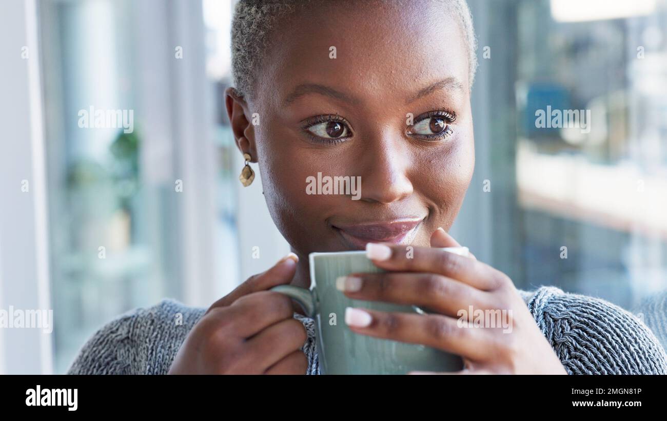 Kaffee trinken, zu Hause entspannen und schwarze Frau, die an Ideen denkt, glücklich im Haus und lächeln im Wohnzimmer der Wohnung. Das Gesicht einer Afrikanerin Stockfoto