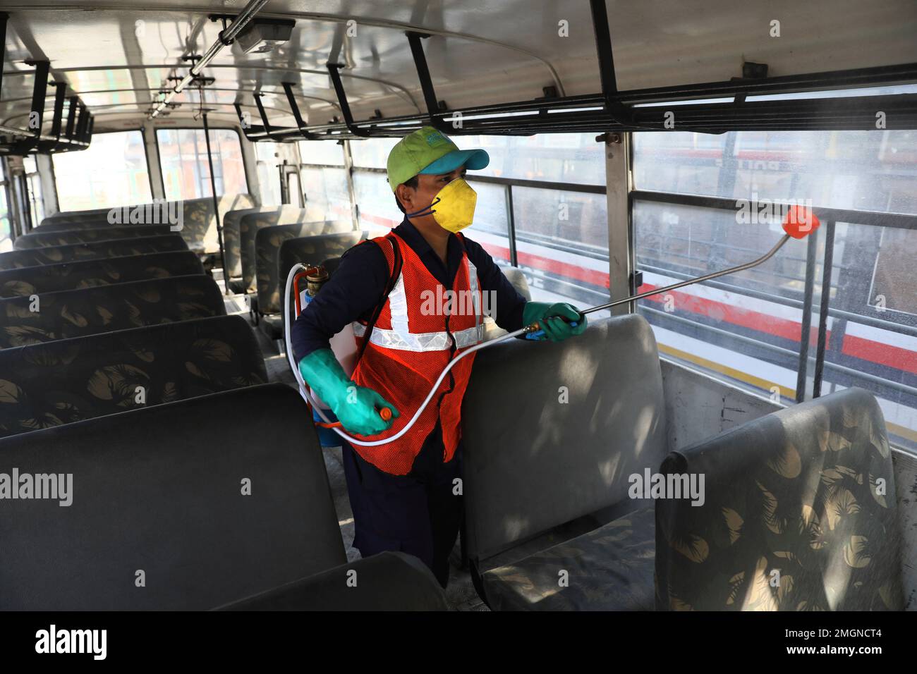 A worker disinfects a police bus as a precaution against COVID-19 in New Delhi, India, Monday, March 16, 2020. The vast majority of people recover from the new virus. According to the World Health Organization, people with mild illness recover in about two weeks, while those with more severe illness may take three to six weeks to recover. (AP Photo/Manish Swarup) Stockfoto