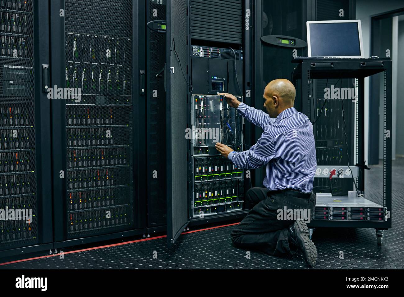 Er kennt sich mit einem Computersystem aus. Ein IT-Techniker, der einen Computer in einem Rechenzentrum repariert. Stockfoto
