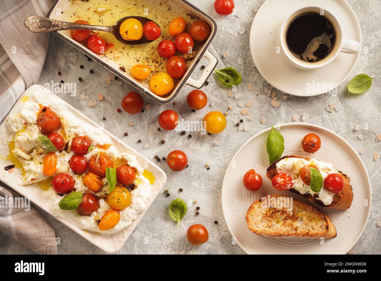 Mittagessen - Burrata-Käse mit gebackenen Tomaten und Toast. Stockfoto