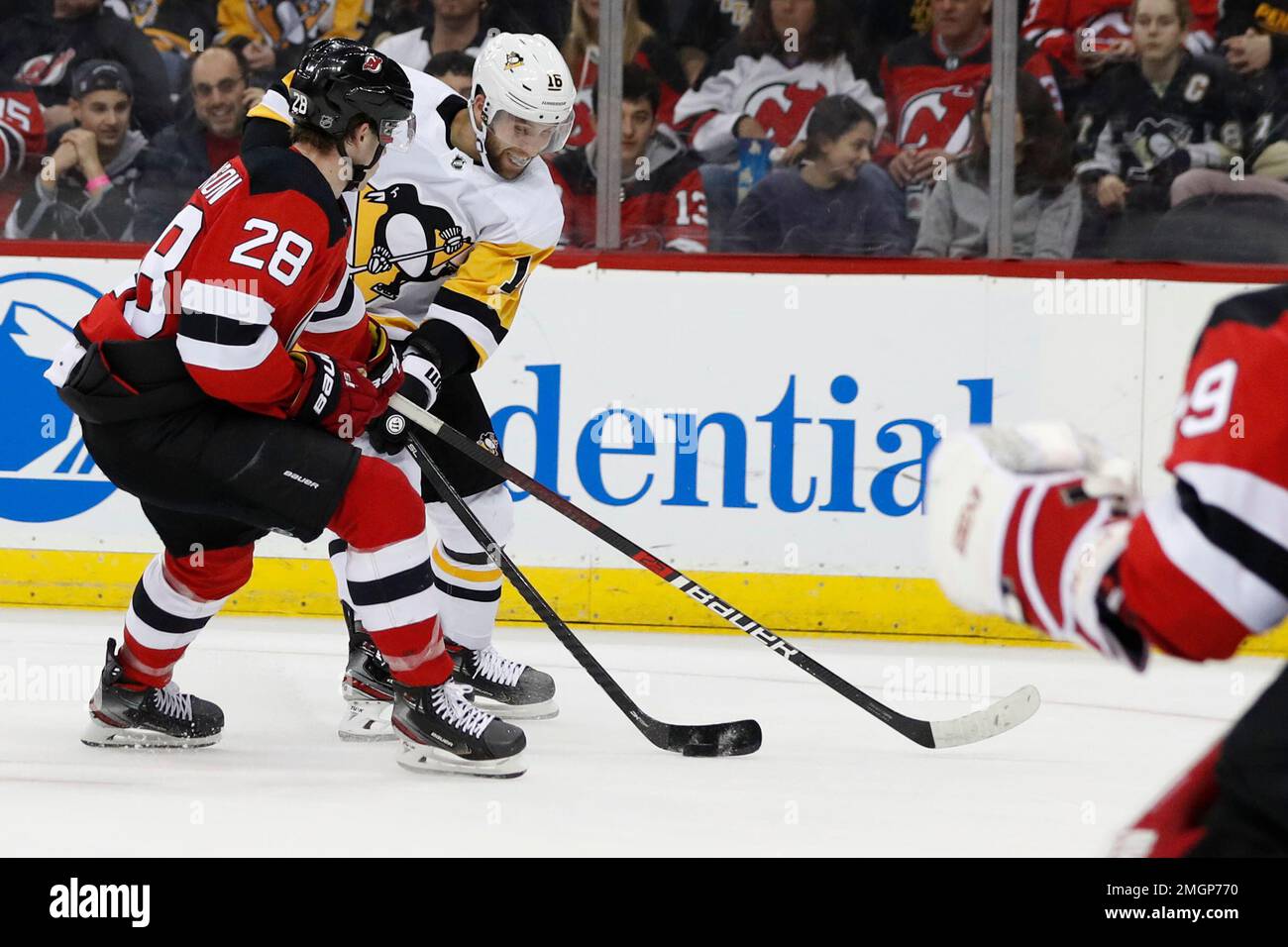 New Jersey Devils defenseman Damon Severson (28) defends against Pittsburgh Penguins left wing Jason Zucker (16) during the first period of an NHL hockey game Tuesday, March 10, 2020, in Newark, N.J. (AP Photo/Kathy Willens) Stockfoto