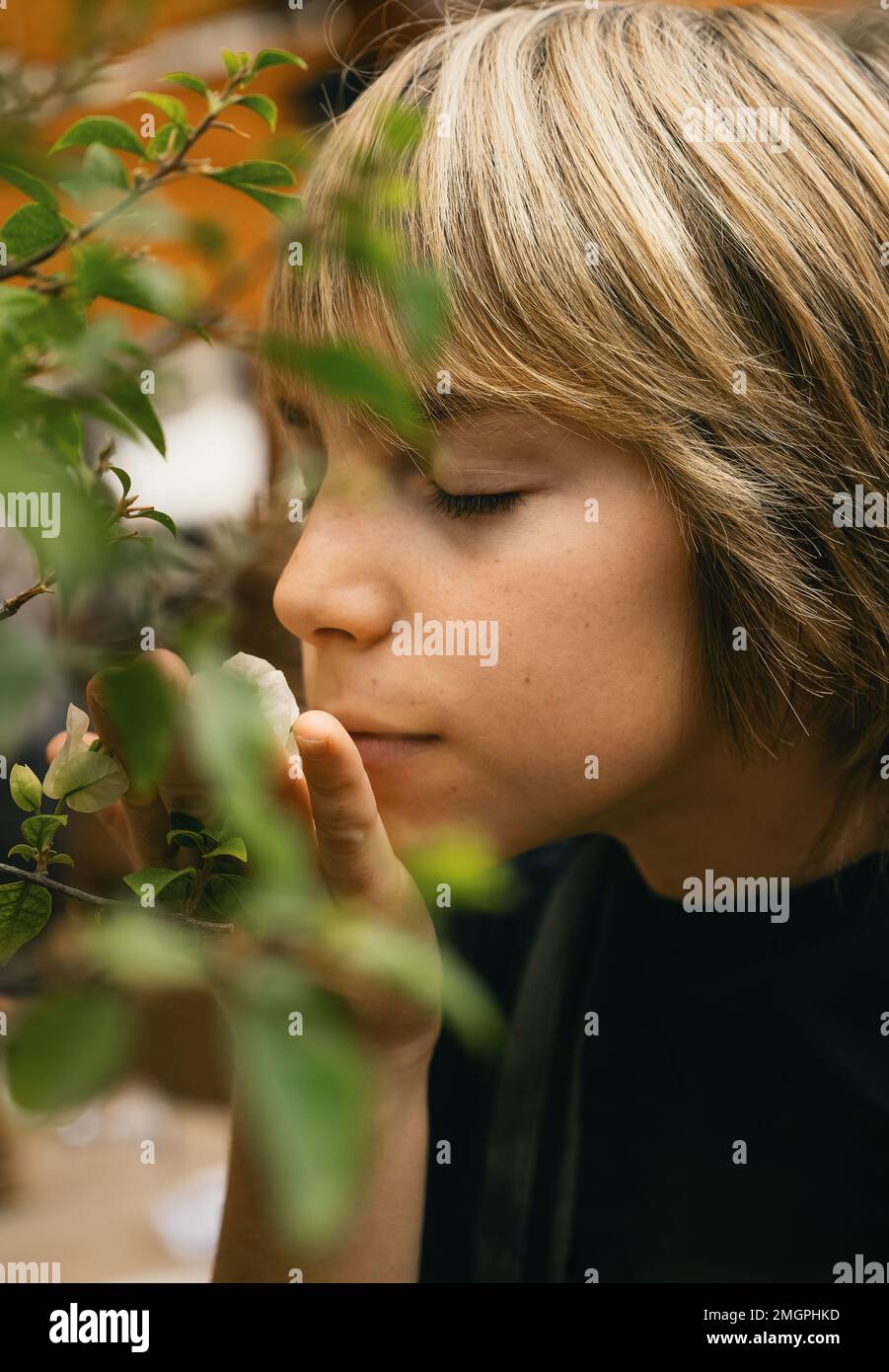 Ein Junge, der Blumen riecht Stockfoto