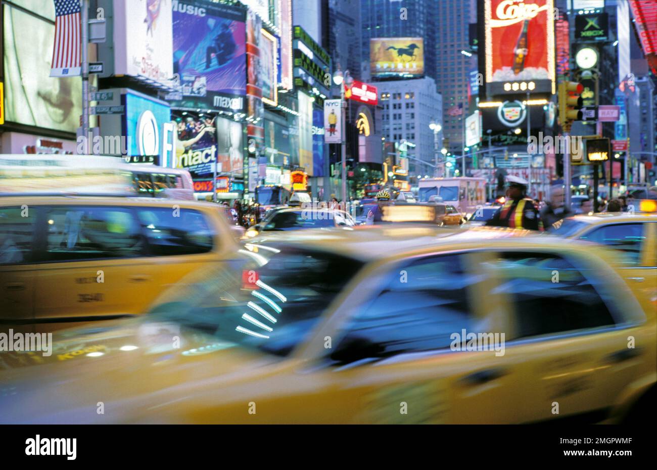 USA, New York, New York City, NYC Times Square mit Verkehr und Taxis in der Abenddämmerung. Stockfoto