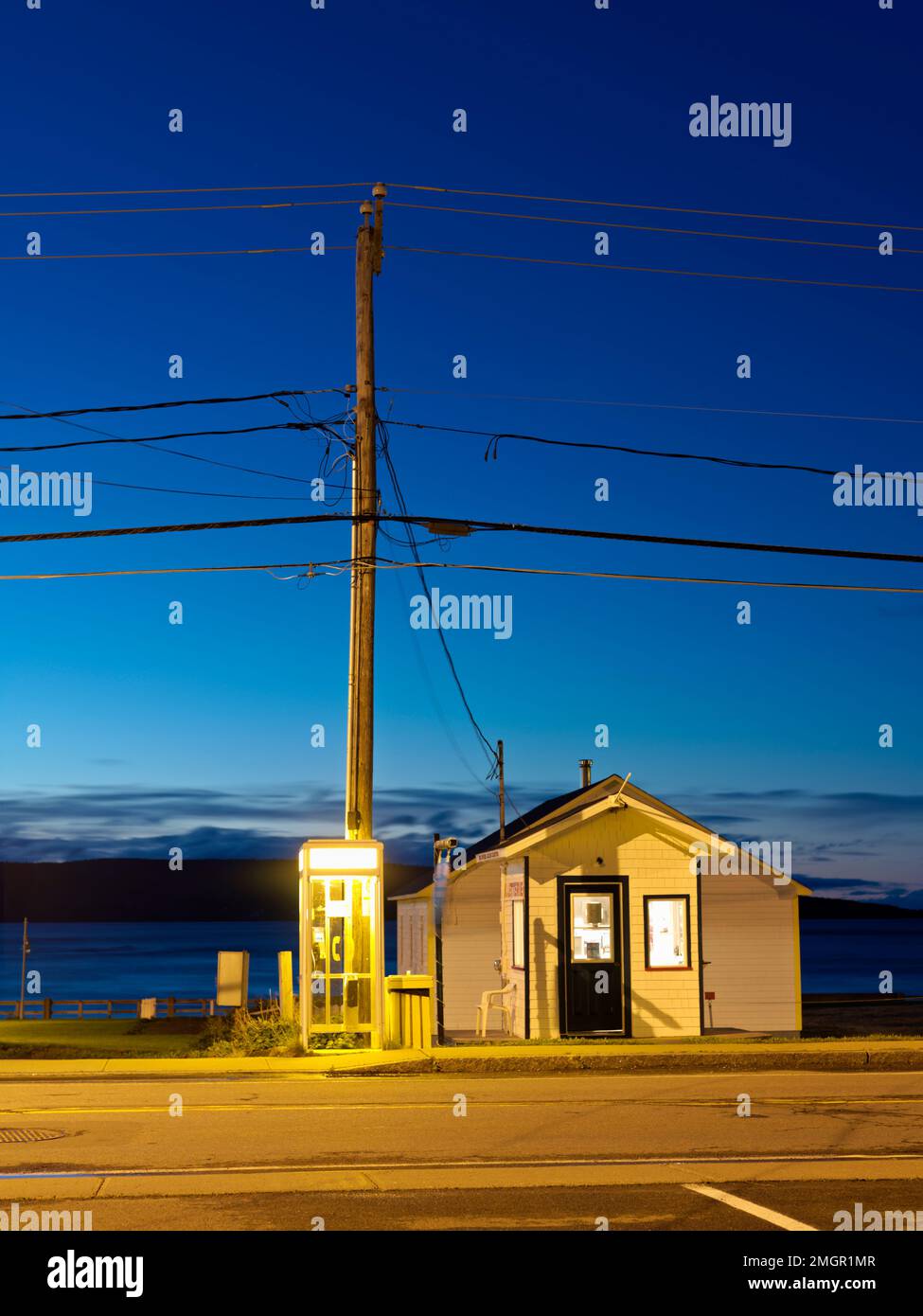 Kanada, Quebec, Gaspese, ein kleines Postgebäude am Straßenrand, beleuchtet in der Dämmerung. Stockfoto
