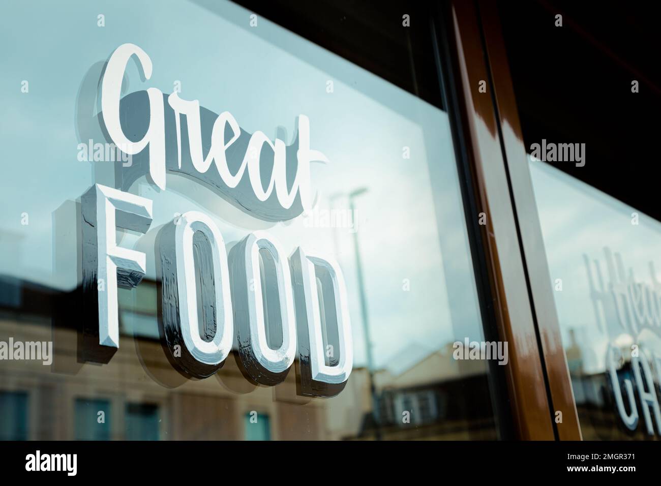 Das Fenster vor dem Restaurant mit den Worten „großartiges Essen“ Stockfoto