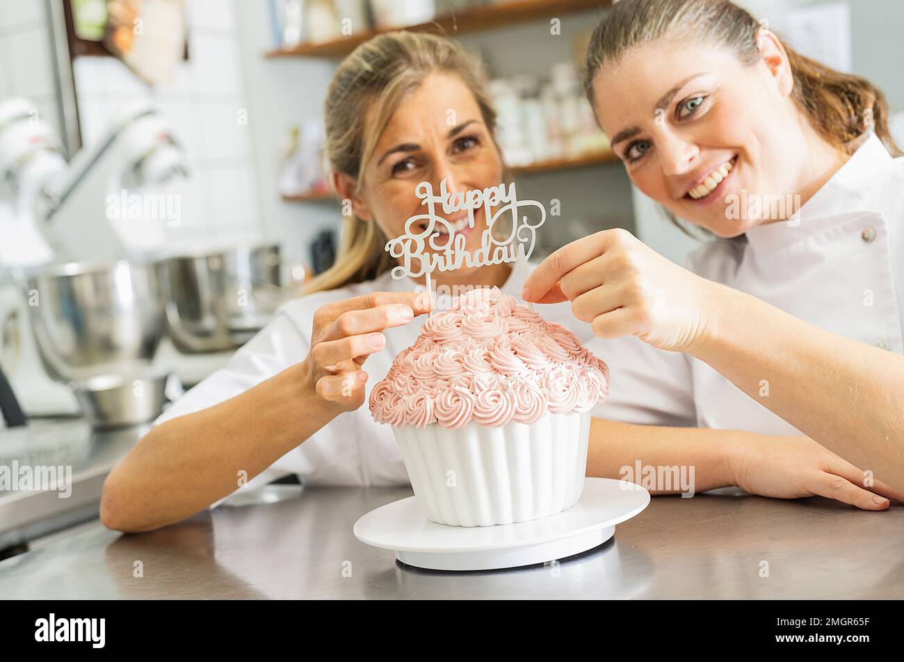 Süßwarenlächelnd und dekoriert großen Geburtstagskuchen-Muffin mit Süßigkeiten in der Bäckerei Stockfoto