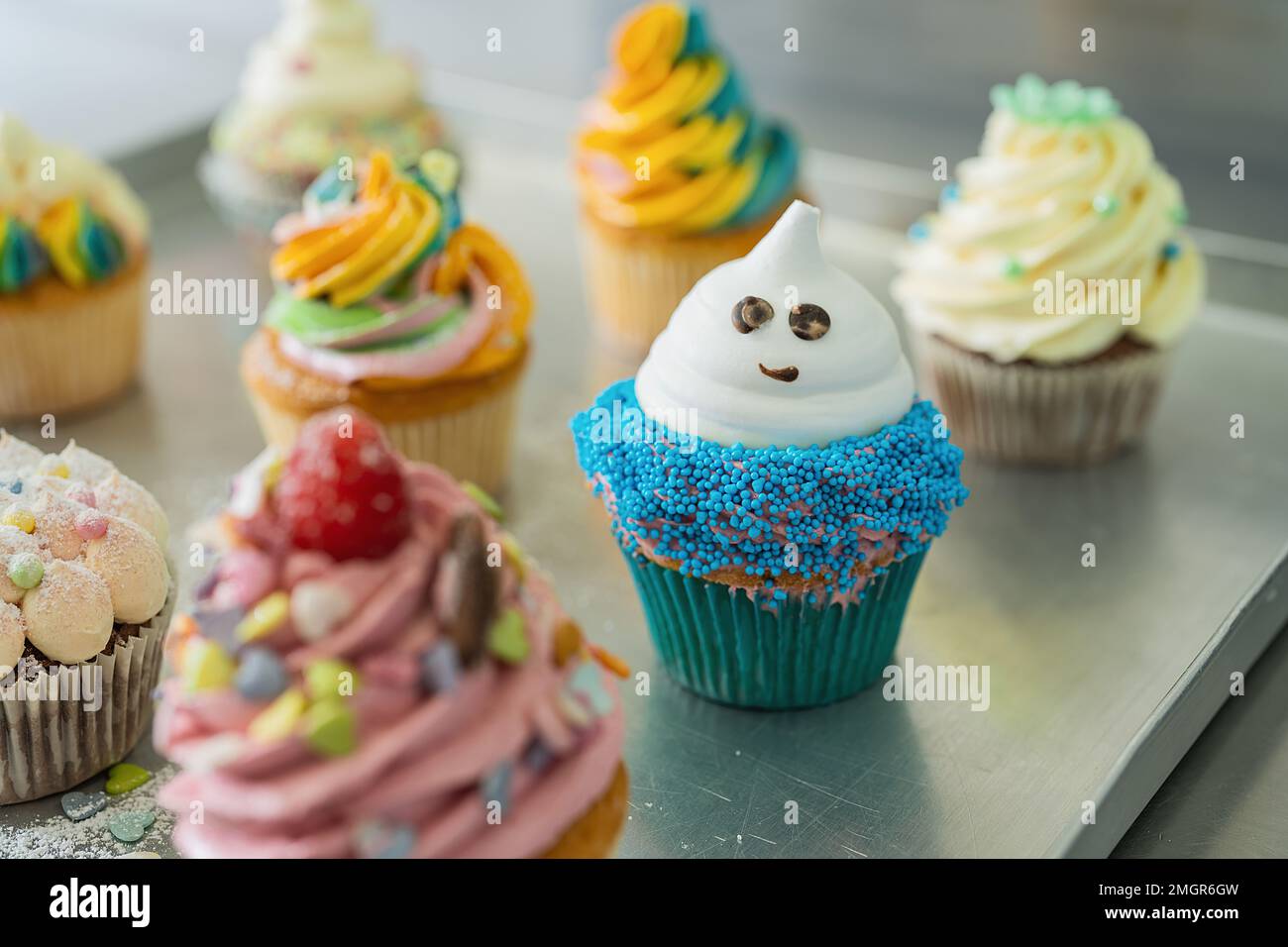 Blauer, pinkfarbener und weißer Tassenkuchen auf blauem Hintergrund zum Geburtstag oder zu halloween in Süßwaren Stockfoto