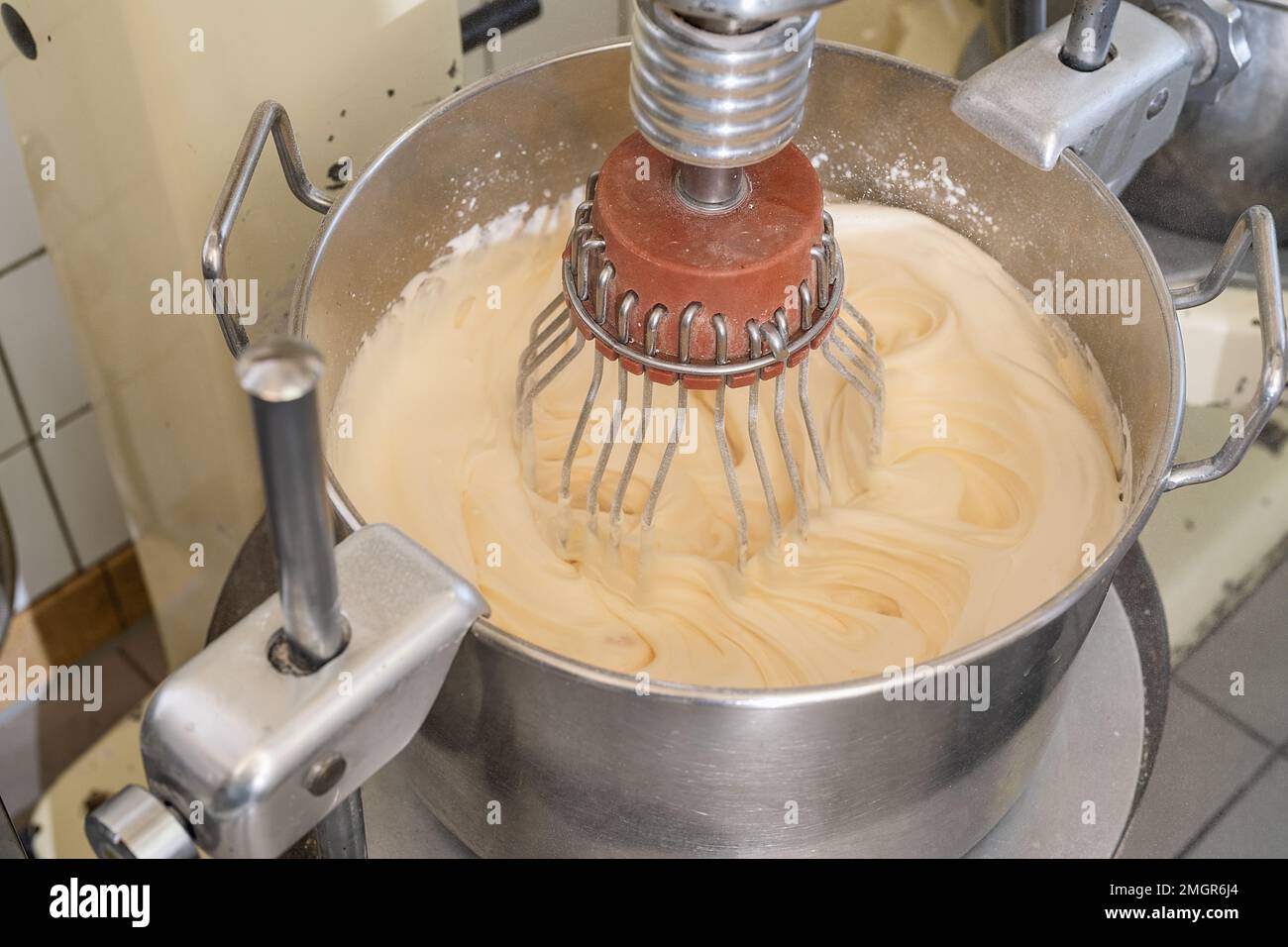 Mischen von Eiercreme in der Mischmaschine. Bild: Konzept einer Bäckerei Stockfoto