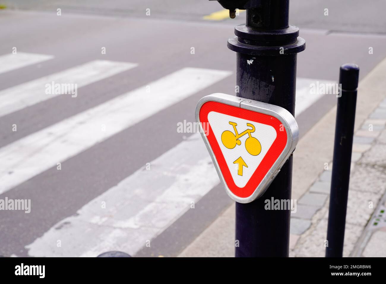 Radfahrer im Stadtverkehr, Schild mit Autorisierung, um geradeaus auf eine Kreuzung zu fahren Stockfoto