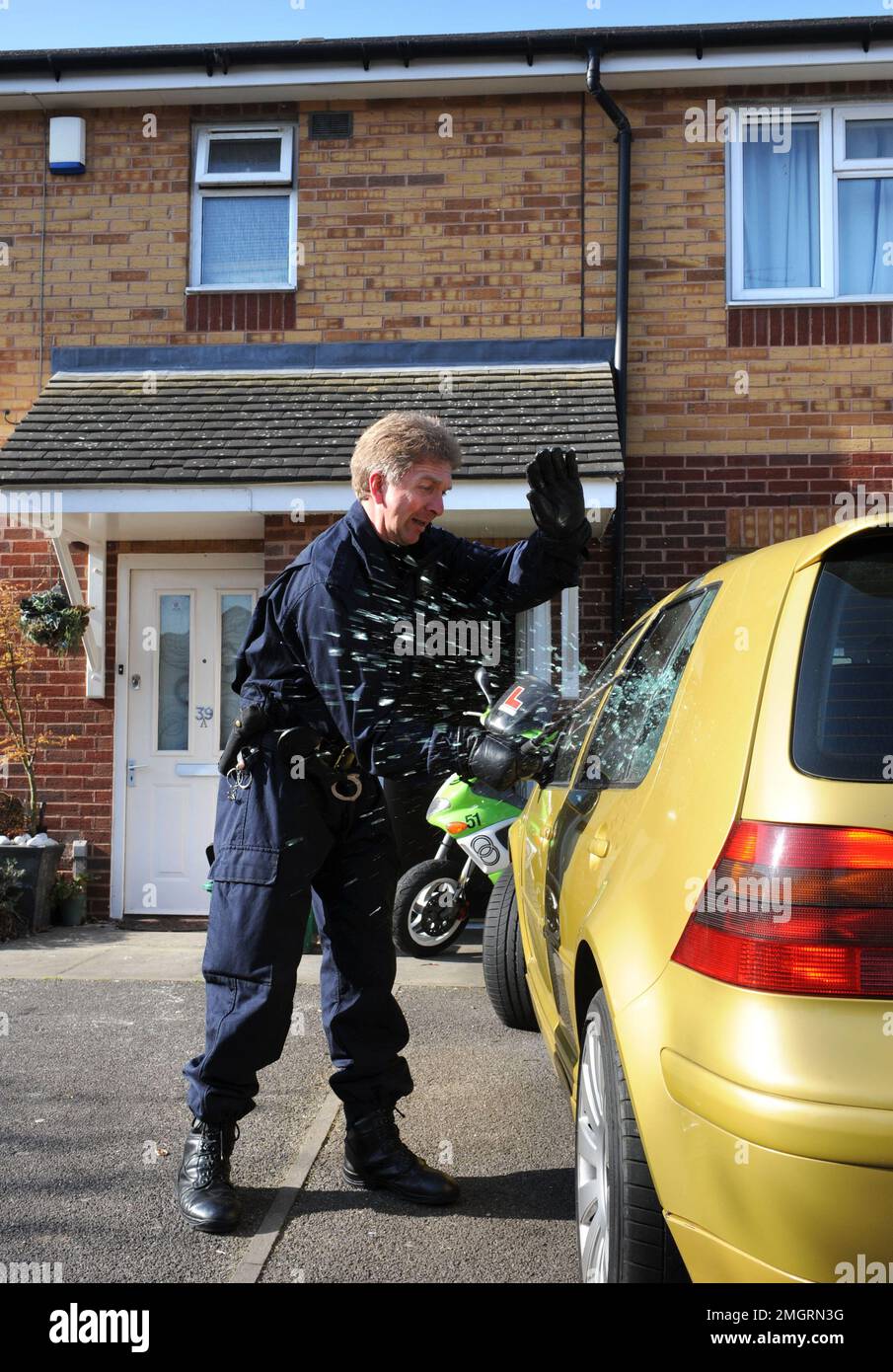 Polizeibeamte des Einsatzteams brechen in ein verdächtiges Auto in Gloucester ein, wo eine von mehreren Morgenangriffen im Rahmen von Operation Z stattfand Stockfoto