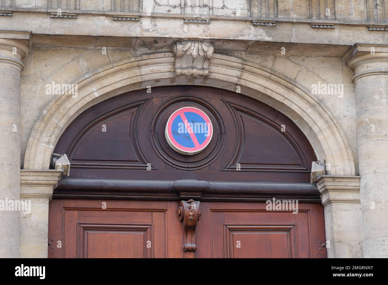 Parken verboten an der alten Gebäudefassade Beschilderung rot blaues Schild am Bogen Stockfoto
