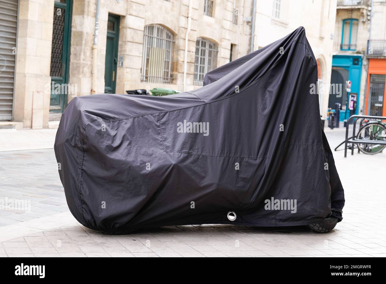 Das Motorrad ist durch eine Kunststoffabdeckung in einem Straßenmotorrad mit Planenjacke geschützt Stockfoto